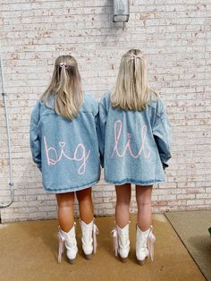 two girls wearing denim jackets with the words big and little written in pink on them