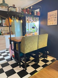 a kitchen with black and white checkered flooring next to a dining room table