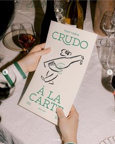 a person is holding up a sign at a table with wine glasses