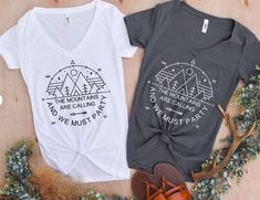 two t - shirts that say the mountains are calling and we must go with it