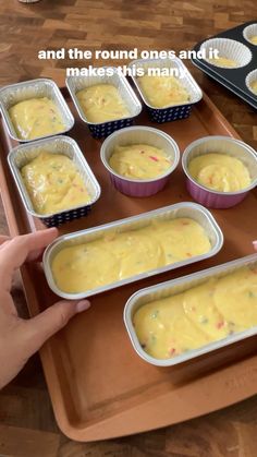 there are many pans with food in them on the tray and one person is pointing at it