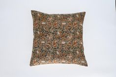 an orange and black decorative pillow on a white background with a brown border in the middle