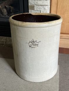 a large white pot sitting next to a fireplace