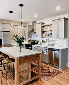 an instagram photo of a kitchen with white cabinets and stainless steel appliances