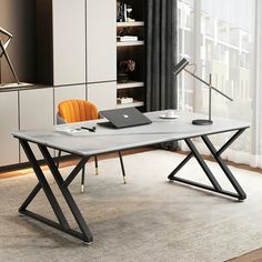 a modern desk with a laptop on it in front of a large window and bookshelf