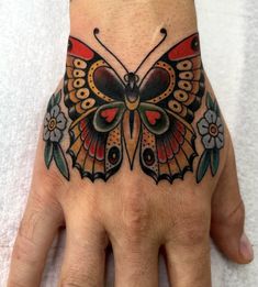 a hand with a butterfly tattoo on it