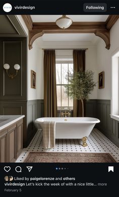 a bathroom with a bathtub, sink and window in the center is featured on instagram