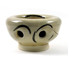 a white ceramic bowl with eyes painted on it