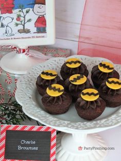 chocolate cupcakes decorated with yellow and black icing on a white cake plate