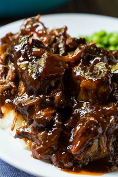 a close up of a plate of food with meat and gravy on it