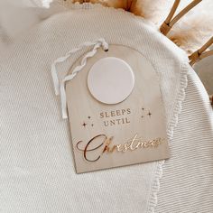 a wooden sign that says sleep until christmas hanging on the back of a white chair