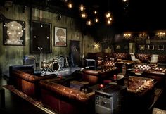 a living room filled with lots of brown furniture and pictures hanging on the wall above it