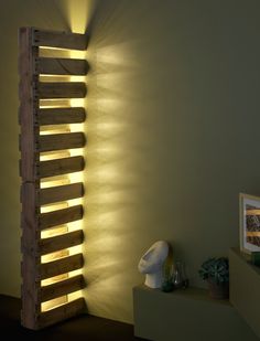 a room with some lights on the wall and a shelf in front of it that is made out of wood