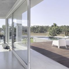 an open room with sliding glass doors leading to a patio and swimming pool in the distance