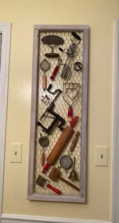 there are many different items in the shadow box on the wall, including scissors and other tools