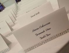 the place cards are set on top of each other, with silver chains hanging from them