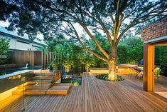 an outdoor deck with trees and lights