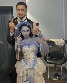 a man and woman dressed up as corpse brides taking a selfie with their cell phones