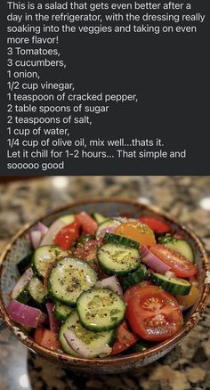 a bowl filled with cucumbers and tomatoes on top of a counter next to a recipe