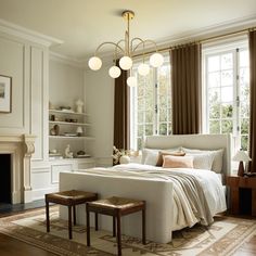 a bedroom with a large bed and two stools in front of the fireplace area