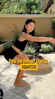 a woman in a black dress is doing squats on a cement slab with the words you've never truly squatted