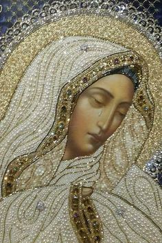 an image of the virgin mary in gold and white with pearls on it's head