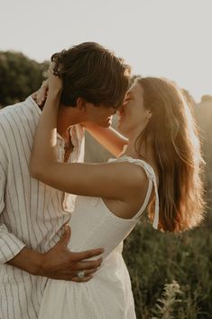 a man and woman are kissing in the field