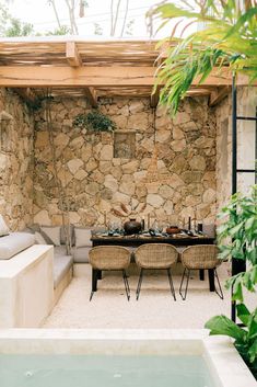 an outdoor dining area next to a pool with chairs and table in the foreground