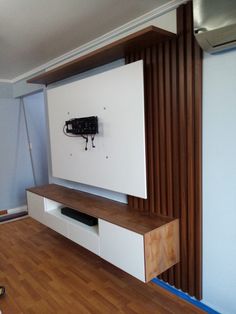 an entertainment center with a flat screen tv mounted to it's wall