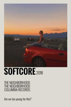 a man sitting on top of a red car