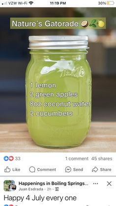 a jar filled with green liquid sitting on top of a wooden table