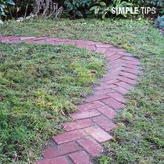 a brick path in the middle of some grass