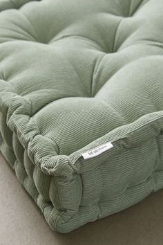 a close up view of a green mattress on the floor with no sheets or pillows