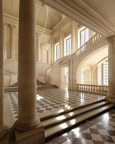 the interior of a large building with columns and checkered flooring on both sides