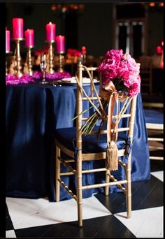 a table with purple flowers on it and candles in the background at a wedding reception