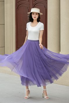 a woman in a white shirt and purple tulle skirt