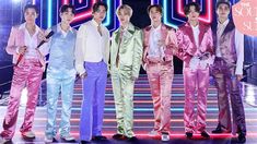 the group of young men are posing for a photo in front of neon signs and lights