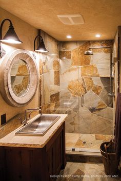 a bathroom with a walk in shower next to a sink and a mirror on the wall