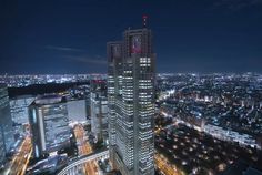 an aerial view of a city at night with skyscrapers lit up in the background