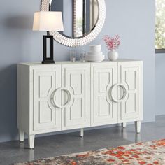 This elegant sideboard brings visual interest and a functional design to your living or dining room. It showcases a raised geometric pattern on the front with wide, round handles and molded detailing for a French country look we love. This 58" wide sideboard is made from solid and engineered wood with a rustic, weathered finish, and it rests on tapered feet. Two sets of cabinet doors open to reveal adjustable shelf space for everything from dishes and glasses to vases and trays. There's also roo Foyer Table Decor Entryway, Elegant Coastal Living Room, Foyer Table Decor, Modern Beach House Decor, Narrow Sideboard, Sideboard White, Storage Sideboard, Wide Sideboard, Foyer Table