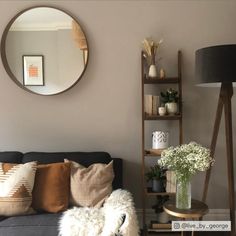 a living room filled with furniture and a round mirror