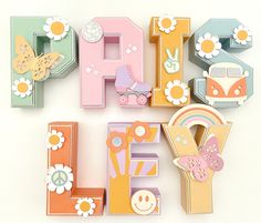 the letter e is made up of wooden letters with flowers and animals on them,