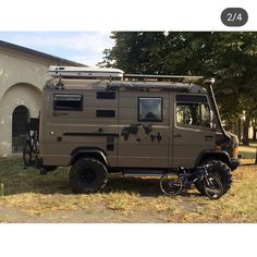 an off - road vehicle parked in front of a house with a bicycle attached to it