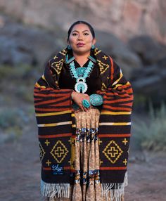 a woman in native clothing poses for the camera