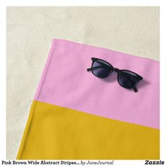 a pair of sunglasses sitting on top of a pink and yellow cloth with black frames