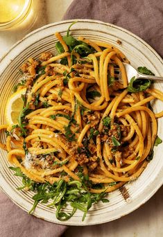 a white plate topped with pasta and greens