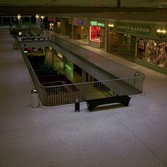 an empty shopping mall at night with the lights on and no people in it,