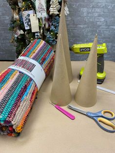 several crafting supplies are sitting on a table next to a christmas tree and some scissors