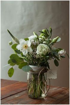 a vase filled with white flowers on top of a wooden table