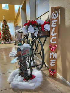 a bicycle is decorated with flowers and other holiday decorations next to a sign that says welcome